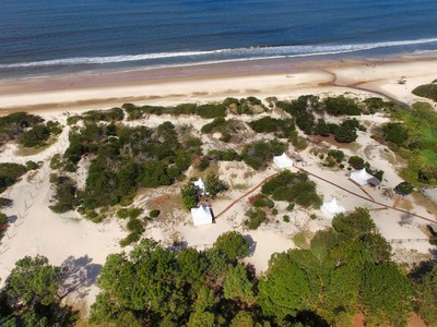 Vista en drone de glamping, quinchado y playa